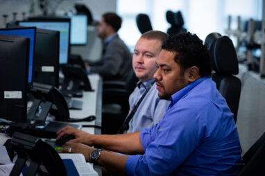 Two crew planners looking over a screen, discussing advanced crew planning strategies.