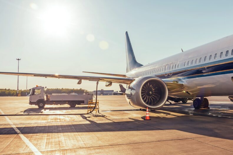 Airplane refueling, connected fuel hose under the fuel tank in the wing.